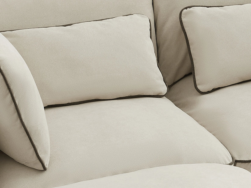 Beige sofa with cushions on a neutral background